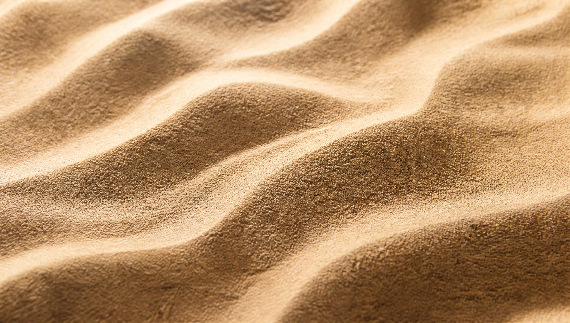 Texture de sable beige ondulé, symbole de l'univers SAND Pilates & Wellness